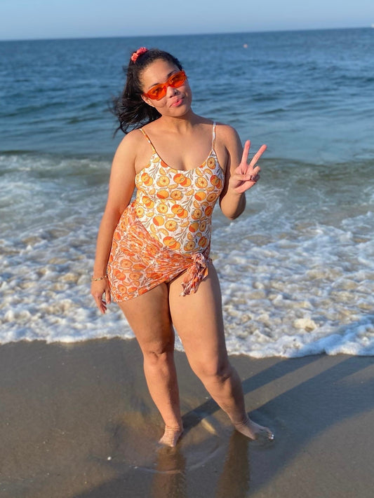 woman at the beach in reversible orange print bikini with matching sarong