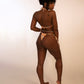 backside of woman in orange print triangle bikini top and string thong bikini bottom