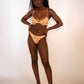 woman wearing a reversible orange / orange print high hip thong bikini bottoms and matching underwire bikini top