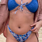 close up of a woman wearing reversible solid and floral blue triangle bikini top and high hip thong bottom with pink flannel