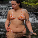 woman in orange print triangle bikini top