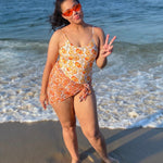 woman at the beach in reversible orange print bikini with matching sarong