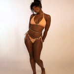 woman in reversed orange print triangle bikini top and tie thong bikini bottom
