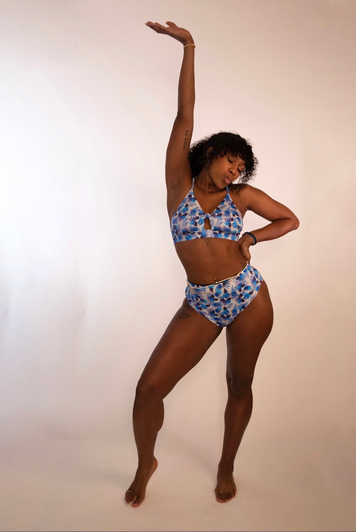 woman in a supportive cross back blue floral bikini top and matching high waisted bottoms