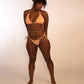 woman in reversible orange print, side tie, adjustable thong bikini bottoms and matching solid orange triangle top
